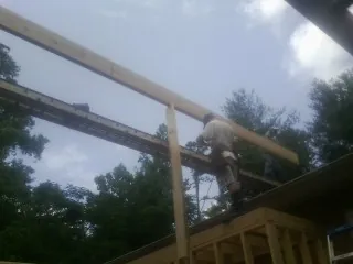 Carpenter setting a ridge beam over a new addition frame — Ice Dam Removal by Roofing Brothers in Dyke