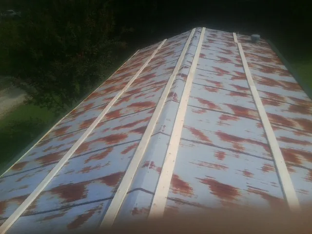 Rusted metal roof panels with new wood purlins before replacement — Storm Damage Roof Repair in Dyke by Roofing Brothers