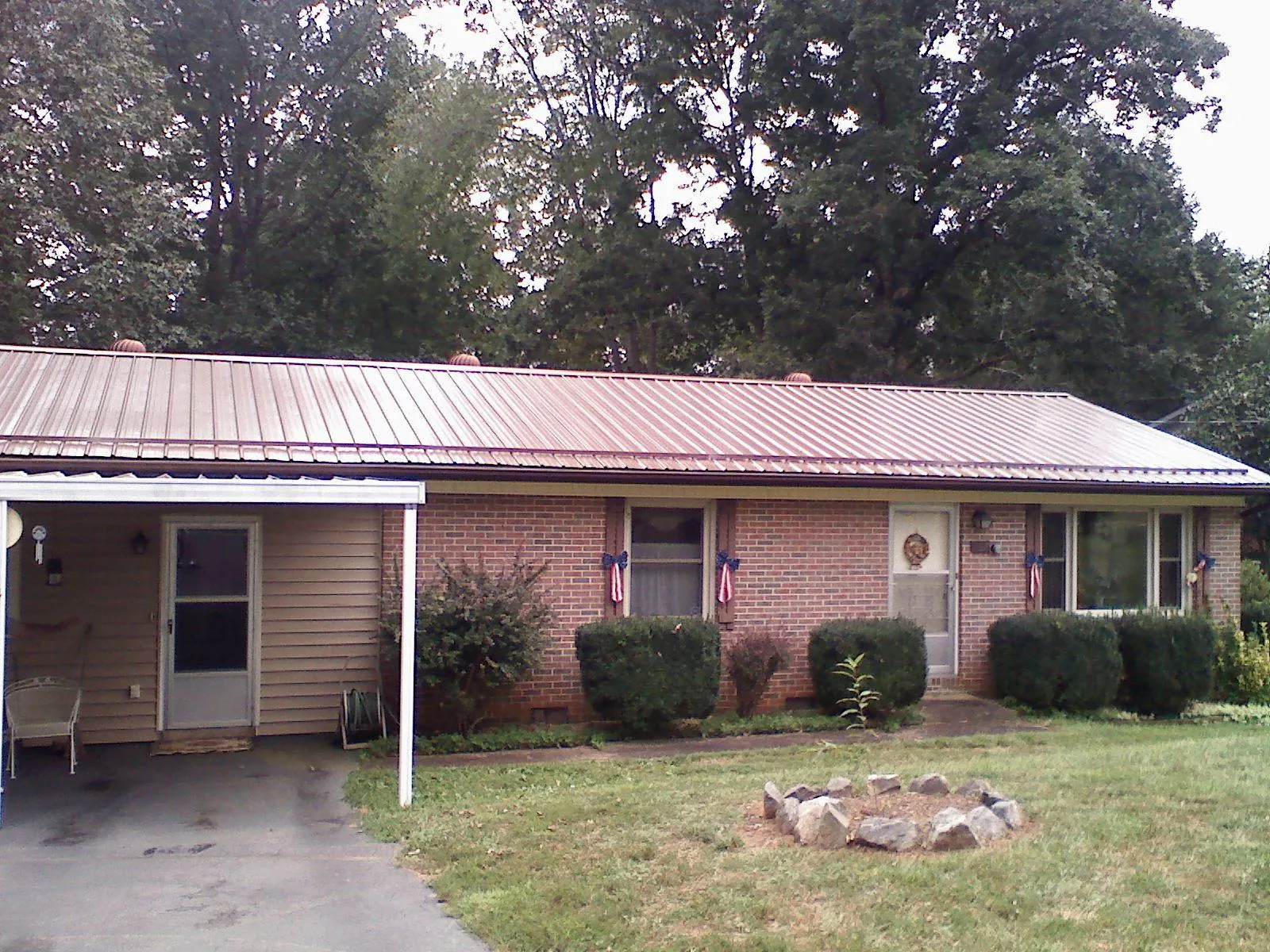 Bronze metal roof and carport on a brick ranch home — Roof Repair work by our crew in Dyke